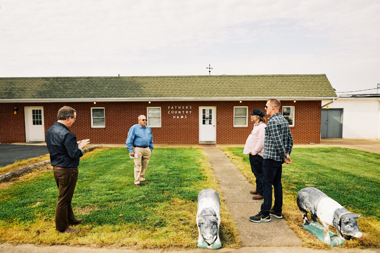 People stand outside a building on the lawn