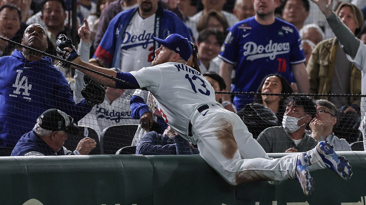 Dodgers' Max Muncy looks stunned as ex-NFL quarterback Rodney Peete snags foul ball from the stands