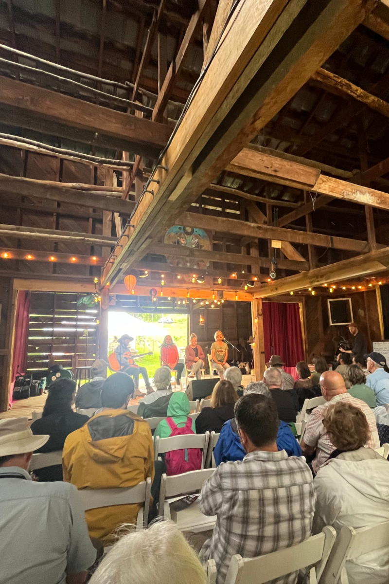 A crowd listening to ballad singers in a farm building