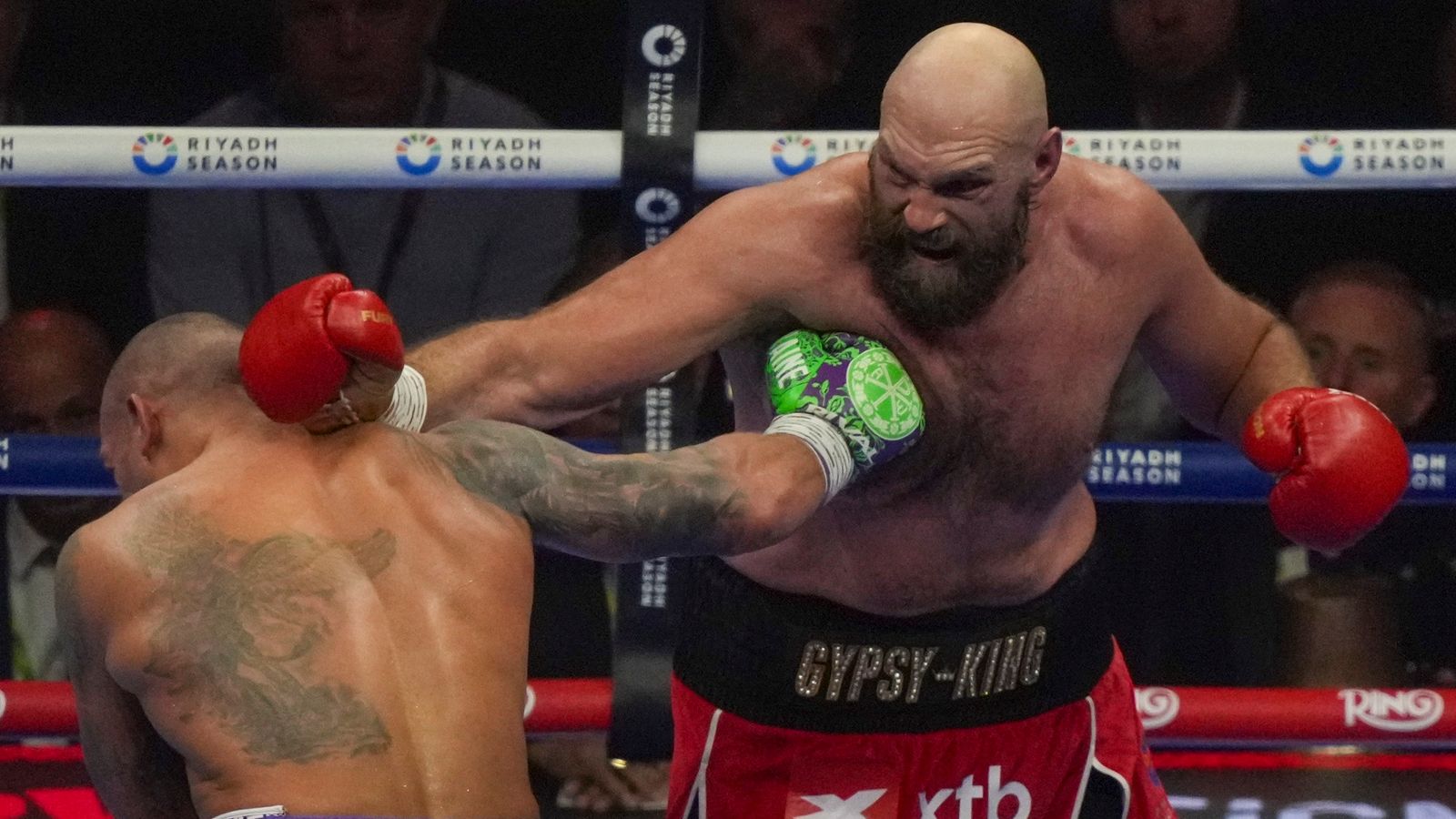 Boxers Britain's Tyson Fury, right, and Ukraine's Oleksandr Usyk compete during their WBA, WBO, and WBC world heavyweight title fight in Riyadh, Saudi Arabia, Saturday, Dec. 21, 2024. (AP Photo/Frank Augstein)