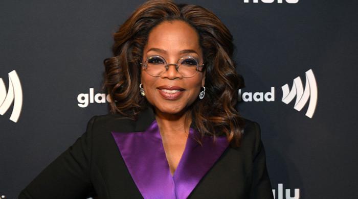 Oprah Winfrey toughs out rainfall with slim physique